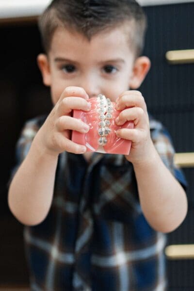 Young boy holding a dental braces model toward camera at a Smyrna TN orthodontic office