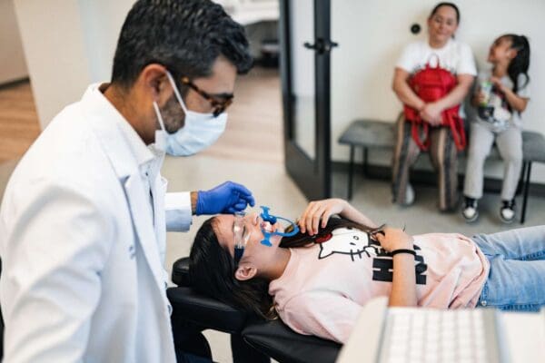 Orthodontist examining a young girl in a treatment chair with family watching at Ruco Braces in Smyrna TN
