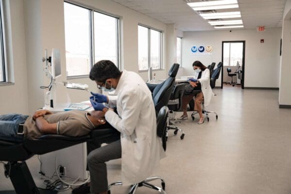 Two orthodontists treating patients in the open-bay treatment room at Ruco Braces orthodontic office in Smyrna TN