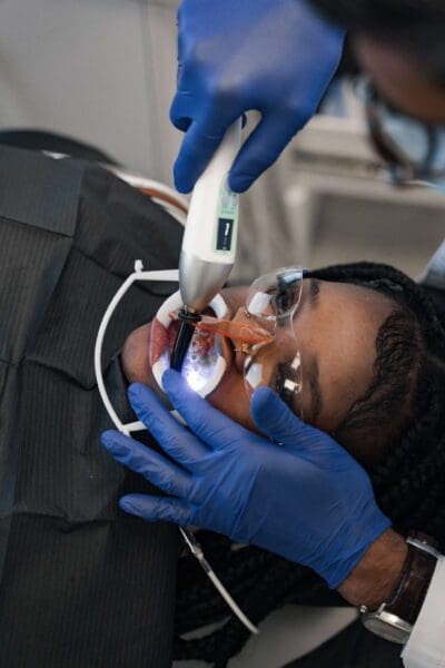 Orthodontist using a curing light to bond braces on a patient at Ruco Braces in Smyrna TN